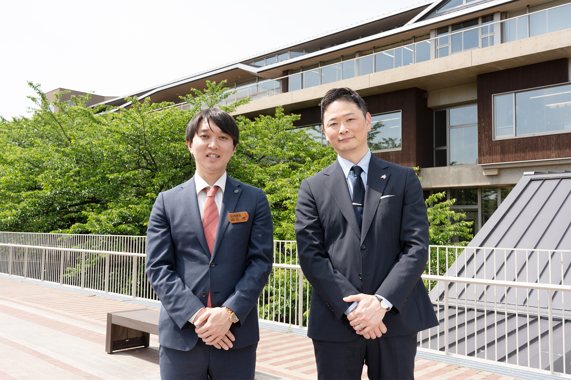 能代市庁舎前に立つ鍋谷市長と若松社長
