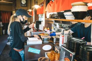 ラーメン屋のホールと厨房での調理