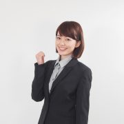 ガッツポーズするスーツの女性